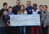 From left: G.H. Dawe Community School Principal Sue Carmichael, Executive Director of the Hockey Alberta Foundation Tim Leer, and Math/Gym teacher Daryl Puzey stand with a handful G.H. Dawe students as the Foundation presents a grant through the Every Kid