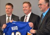 Joel Ward (centre), RDC President and CEO, receives a special Hockey Alberta jersey from Rob Litwinski, Hockey Alberta CEO and Terry Engen, Hockey Alberta Board Chair.