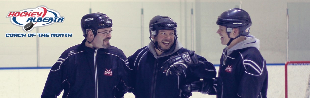 Hockey Alberta’s February Coach of the Month, Jason Oakey (middle), shares a laugh his fellow coaches during practice.